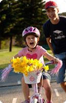 A girl on bike with daffodils in the basket