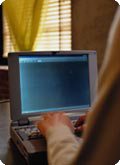A computer seen over a man's shoulder