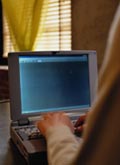 A computer seen over a man's shoulder