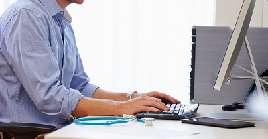 A doctor typing at a computer