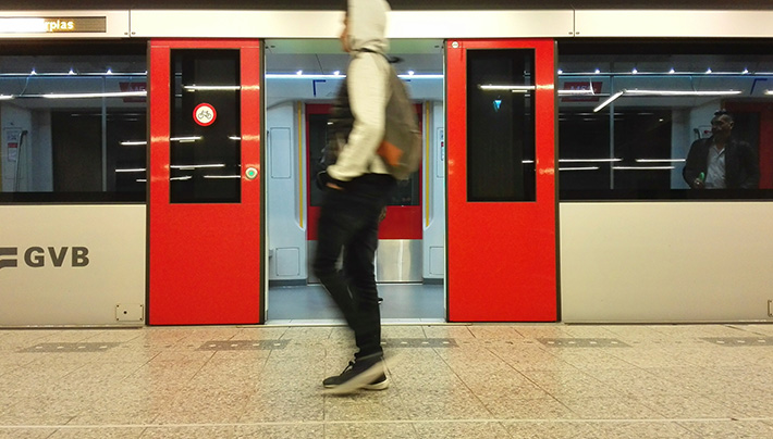 Man standing in front of open train doors in subway
