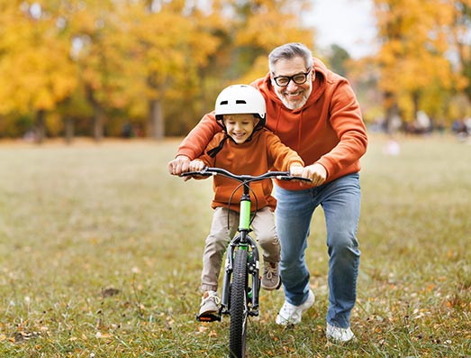 Dad helping a boy to ride a bike