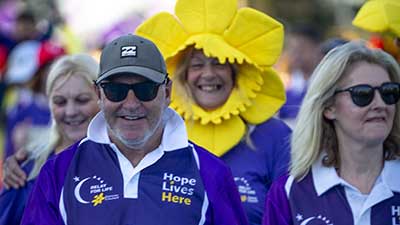 People wearing Relay For Life uniforms, one with a daffodil hood