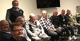 Men in support group smiling in row